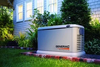 Generac standby generator on brick pad with landscaping and home exterior