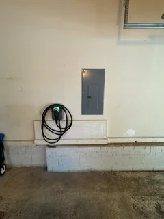 Installed electrical outlet box with gray cover plate and routed wiring in interior wall