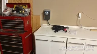 Electrical outlet installation above garage workbench with red tool chest