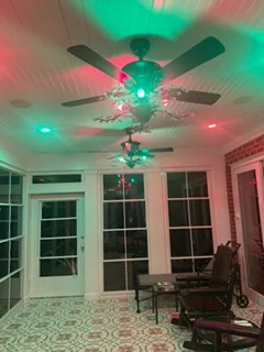 Ceiling fan with multi-color LED lighting installed in residential room with windows