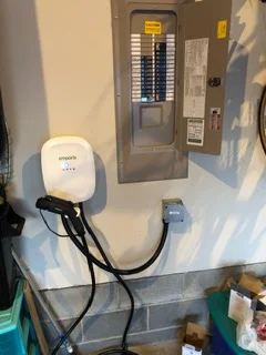 Level 2 EV charger mounted on exterior wall with electrical panel connection and cable management