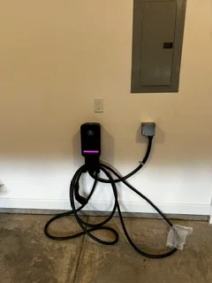 Black Level 2 EV charger mounted on wall with coiled charging cable